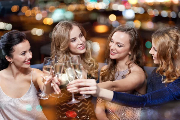 Mulheres felizes com taças de champanhe no clube noturno — Fotografia de Stock