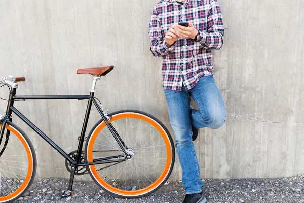 スマート フォンと自転車の流行に敏感な男のクローズ アップ — ストック写真