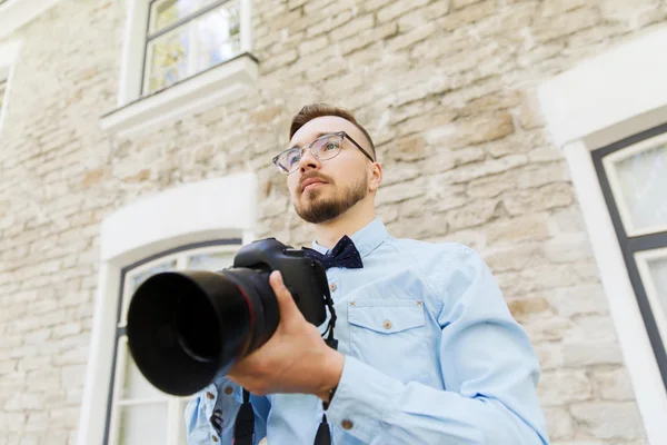 Jonge hipster man met digitale camera in stad — Stockfoto