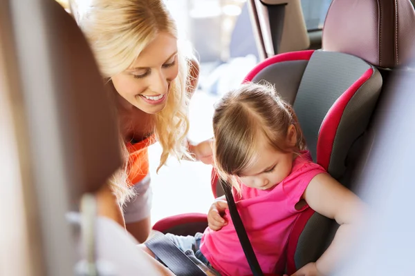 Feliz madre abrochamiento niño con cinturón de seguridad de coche —  Fotos de Stock