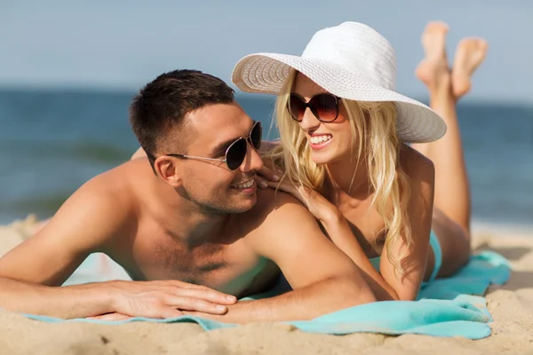 Счастливая пара в купальниках, лежащая на пляже — стоковое фото