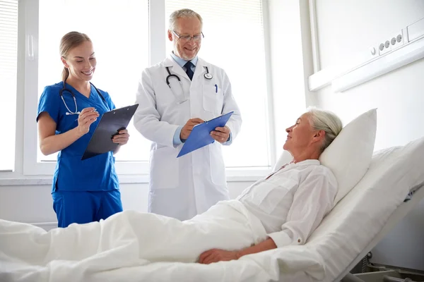 Arzt und Krankenschwester besuchen Seniorin im Krankenhaus — Stockfoto