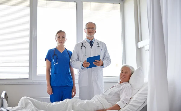 Arts en verpleegkundige senior vrouw in ziekenhuis bezoeken — Stockfoto