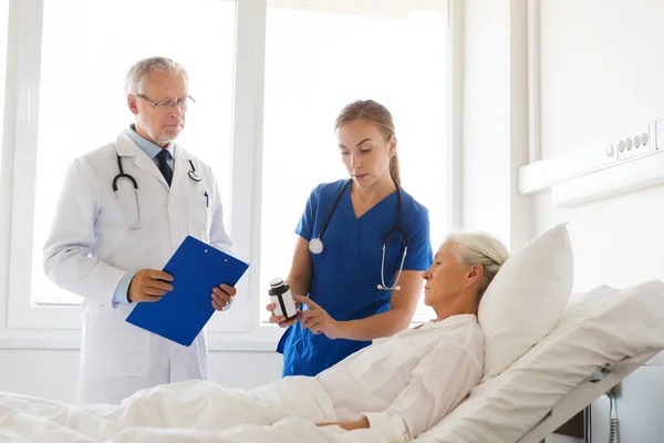 Arzt gibt Seniorin im Krankenhaus Medikamente — Stockfoto