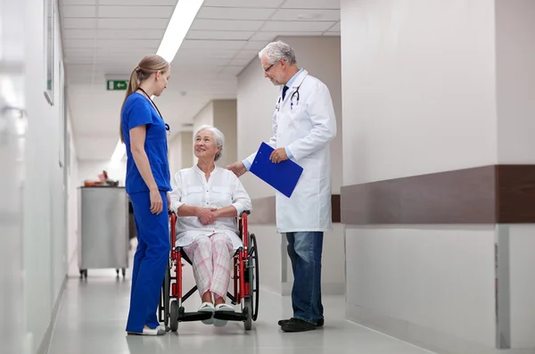 Médecins et femmes âgées en fauteuil roulant à l'hôpital — Photo