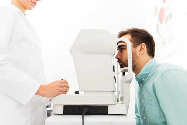 Óptico com autorefrator e paciente na clínica — Fotografia de Stock