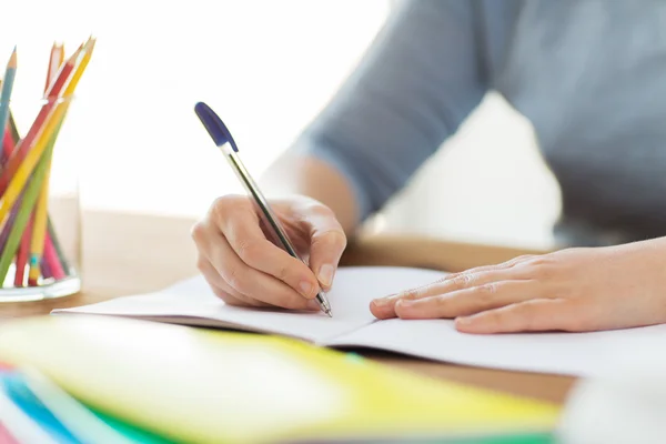 Close up of student writing to notebook at home — Stock Photo, Image