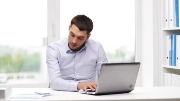 Homem de negócios com laptop chamando no smartphone — Vídeo de Stock