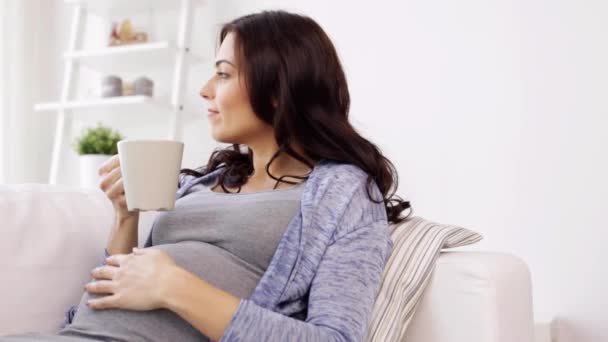 Щаслива вагітна жінка з чашкою п'є чай вдома — стокове відео