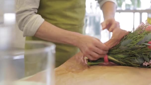 Florist inslagning blommor i papper på blomsteraffär — Stockvideo