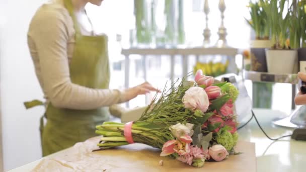 Floristería mujer con flores y hombre en floristería — Vídeos de Stock