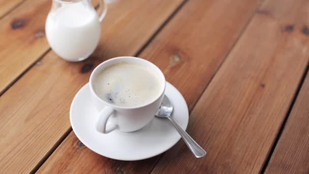 Hand laten vallen van suiker in het koffiekopje op tafel — Stockvideo