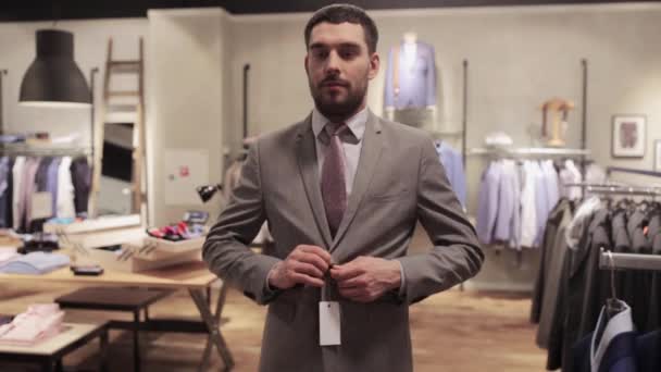 Мужчина делает селфи на смартфоне в магазине одежды — стоковое видео