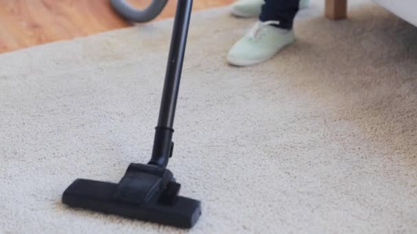 Woman with vacuum cleaner cleaning carpet at home — Stock Video