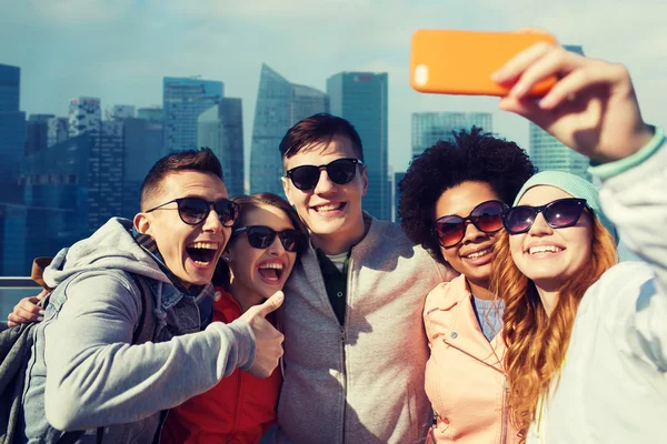 Amigos sonrientes tomando selfie con teléfono inteligente —  Fotos de Stock