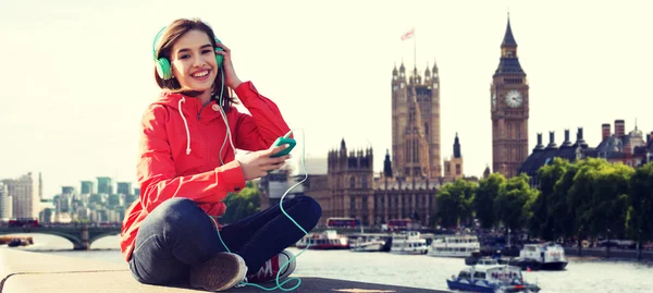 Felice giovane donna con smartphone e cuffie — Foto Stock