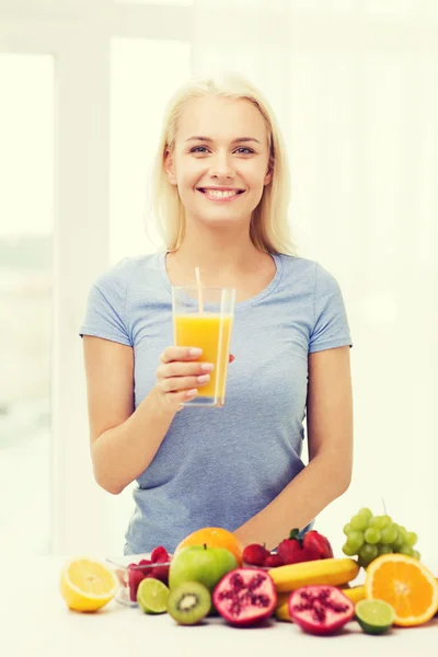 Smiling woman drinking fruit juice at home — 图库照片