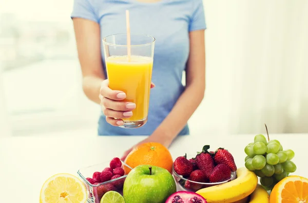 Primer plano de la mujer sosteniendo jugo de naranja con frutas —  Fotos de Stock