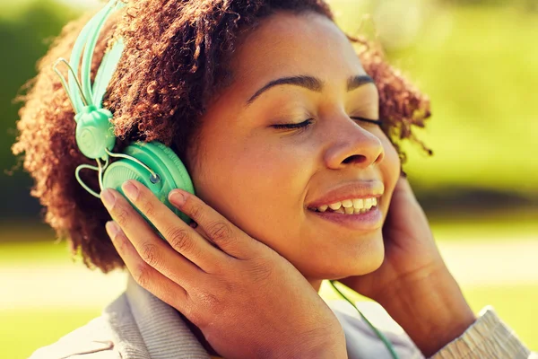 Femme africaine dans les écouteurs écouter de la musique — Photo