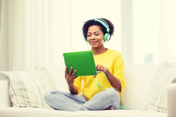 Glückliche Afrikanerin mit Tablet-PC und Kopfhörer — Stockfoto