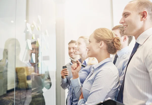 Smiling business people with marker and stickers — Stock Photo, Image