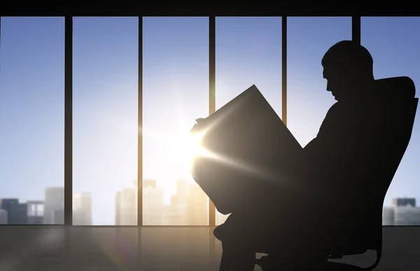 Silhouette of businessman reading documents — 图库照片