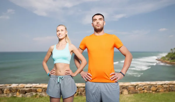 Happy couple exercising over sea or beach — Stock Photo, Image