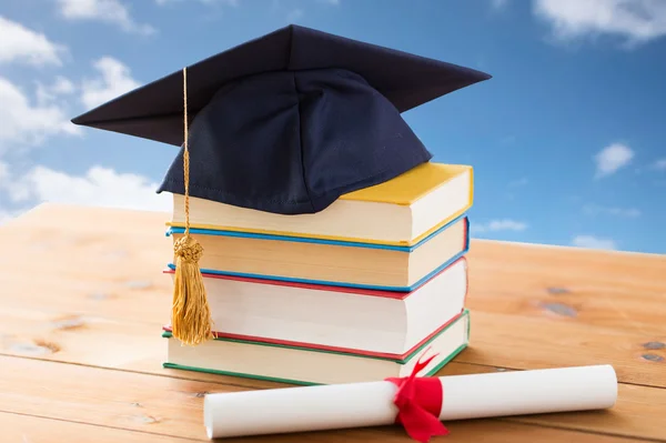 Cierre de libros con diploma y mortero —  Fotos de Stock