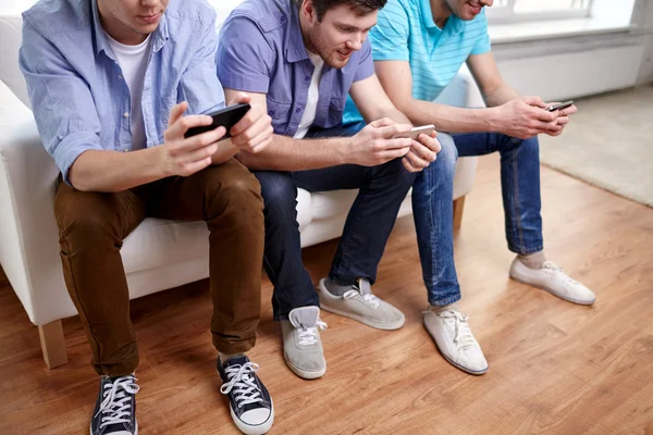 Close up of happy friends with smartphones at home — Stock Photo, Image