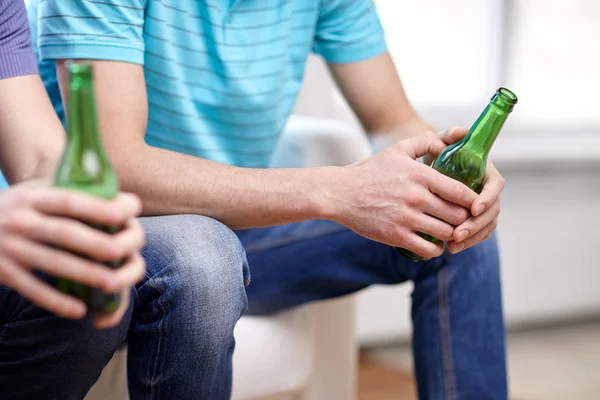 Close up of male friends drinking beer at home — Stock Photo, Image