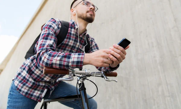 Hipster człowieka w słuchawki z smartphone i rower — Zdjęcie stockowe