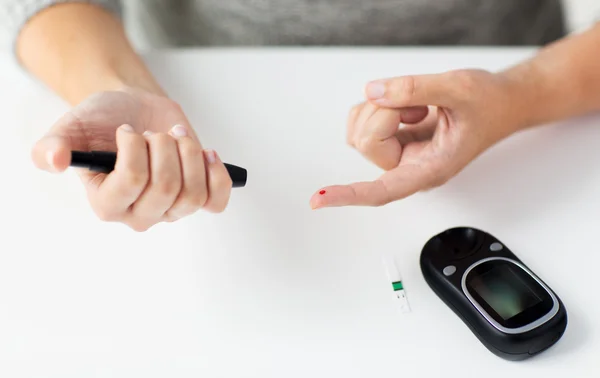 Nahaufnahme einer Frau, die Bluttest per Glukometer macht — Stockfoto