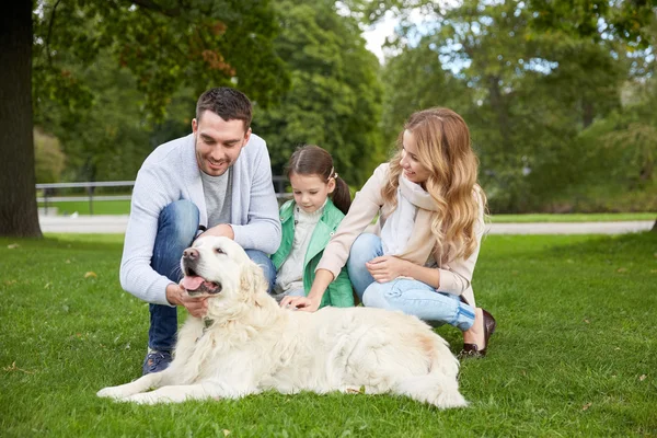 Glückliche Familie mit Labrador-Retriever-Hund im Park — Stockfoto