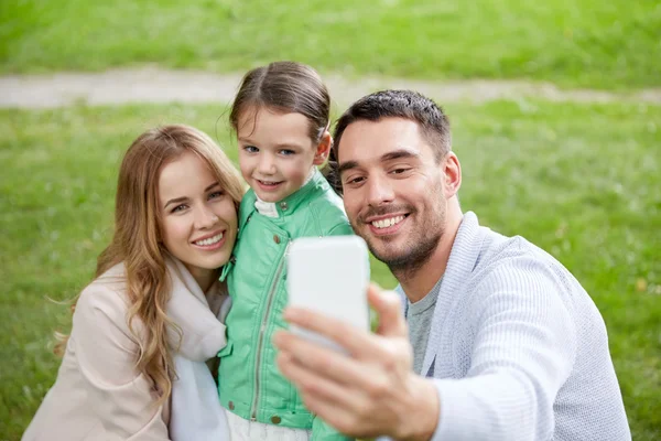 Familia feliz tomando selfie por teléfono inteligente al aire libre —  Fotos de Stock