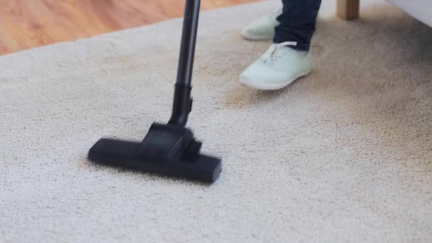 Woman with vacuum cleaner cleaning carpet at home — Stock Video