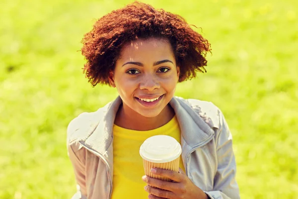 Smiling african woman drinking coffee outdoors — Stock Photo, Image