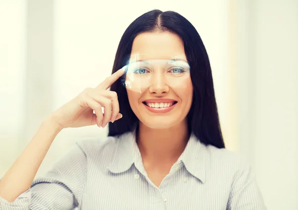 Lächelnde Frau zeigt auf futuristische Brille — Stockfoto