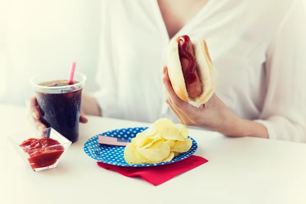 Close up of woman eating hot dog with cola — Stock Photo, Image