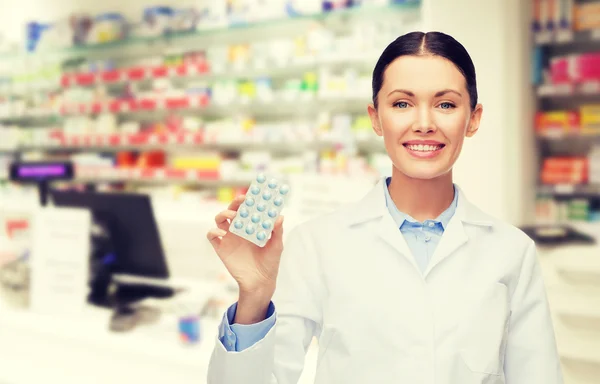 Woman pharmacist with pills drugstore or pharmacy — ストック写真