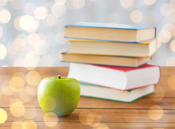 Primer plano de libros y manzana verde sobre mesa de madera —  Fotos de Stock