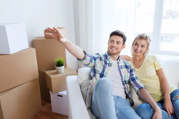 Pareja con cajas mudándose a casa nueva y soñando — Foto de Stock