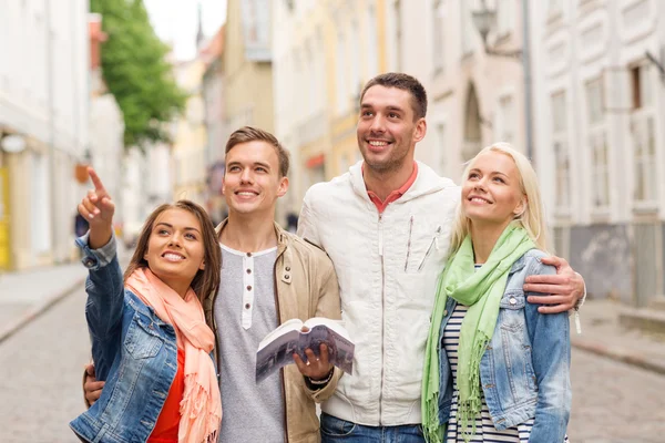 Group of friends with city guide exploring town — Stock Photo, Image