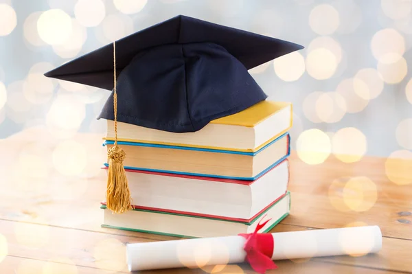 Close up van boeken met diploma en mortarboard — Stockfoto