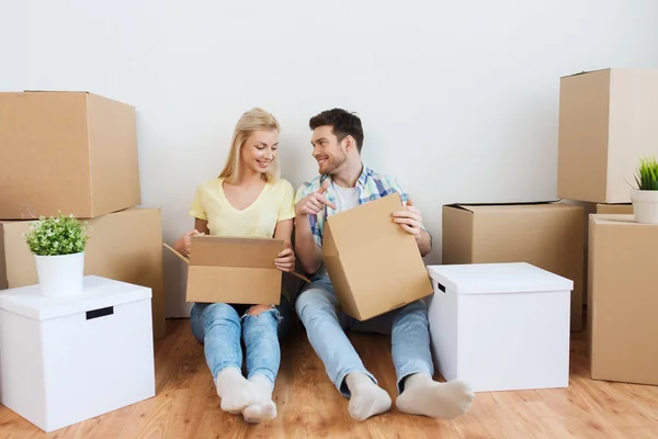 Χαμογελώντας ζευγάρι με πολλά κουτιά που μετακινούνται σε νέο σπίτι — Φωτογραφία Αρχείου