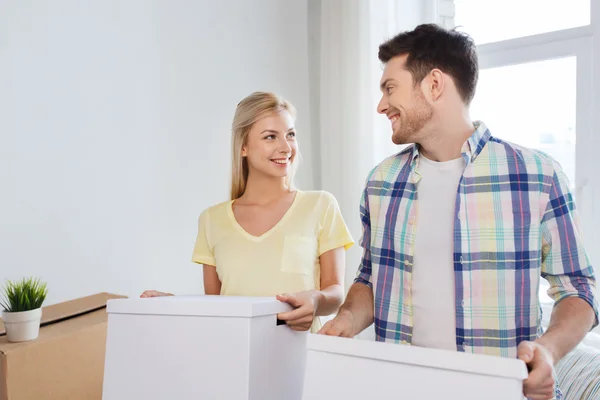 Sonriente pareja con grandes cajas moviéndose a nuevo hogar — Foto de Stock