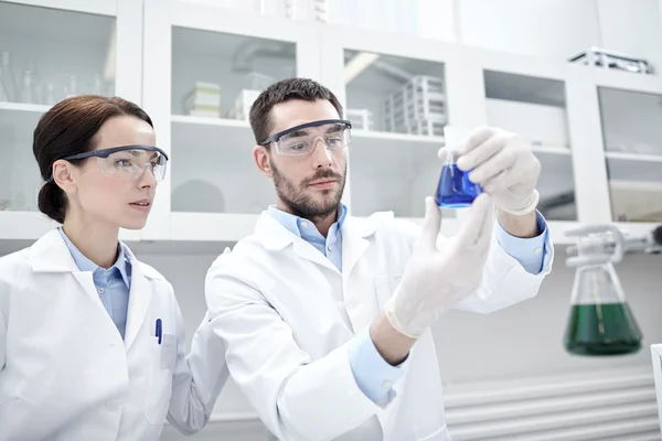 Jóvenes científicos haciendo pruebas o investigaciones en laboratorio —  Fotos de Stock