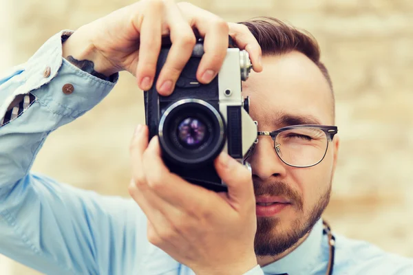 Young hipster man with film camera in city — Stock Photo, Image