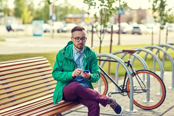 Gelukkig jonge hipster man met smartphone en fiets — Stockfoto