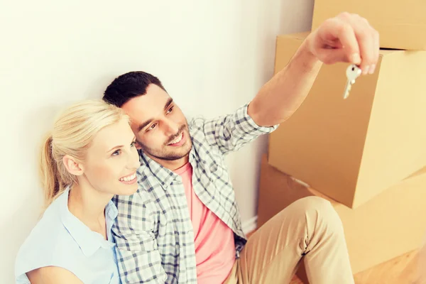 Couple with key and boxes moving to new home — Stock Photo, Image