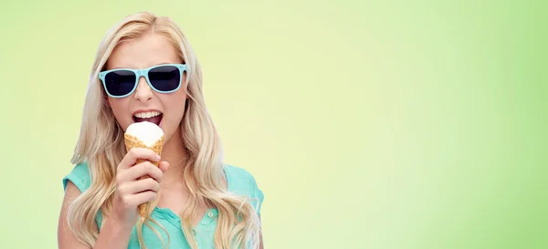 Szczęśliwa młoda kobieta w okulary jeść lody — Zdjęcie stockowe